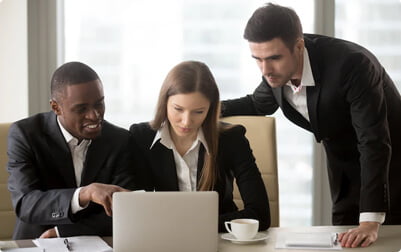 A group of people looking at a laptop