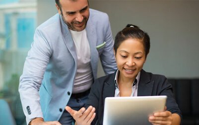 A person and person looking at a tablet